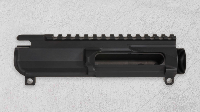 A black AR-15 rifle part placed on a white background