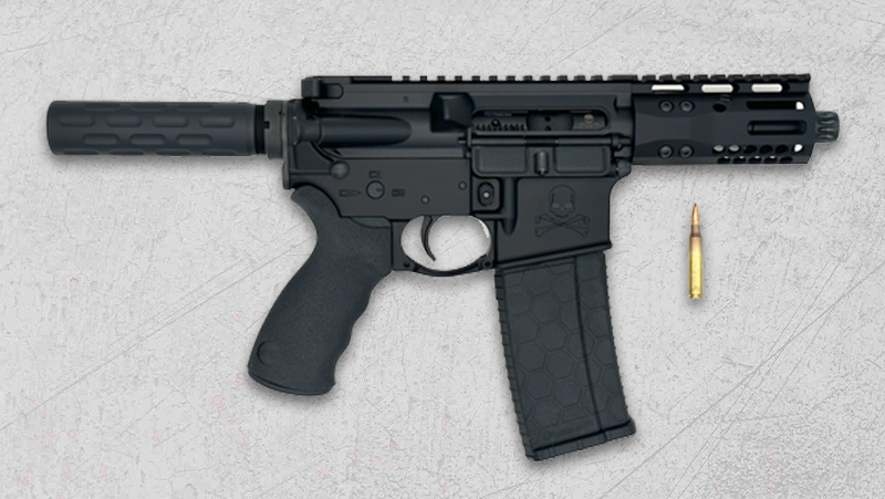 A black AR-15 pistol with a bullet placed on a white backdrop