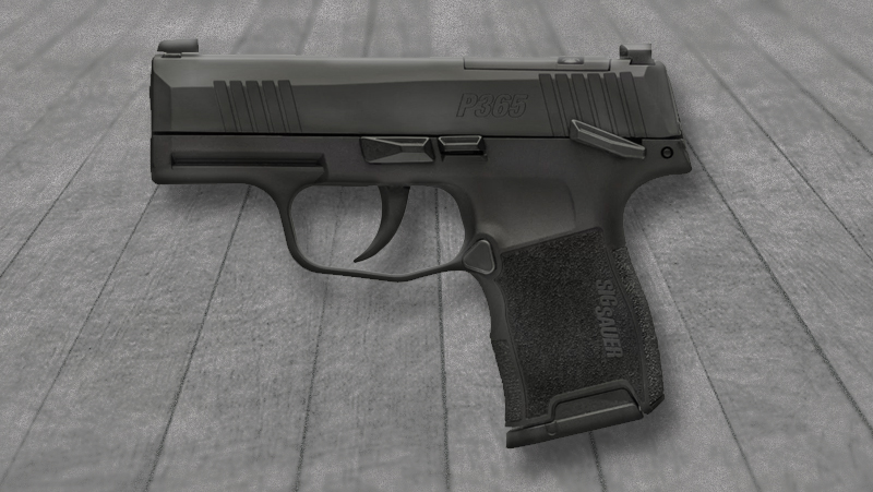 A black Sig Sauer P365 on a gray surface