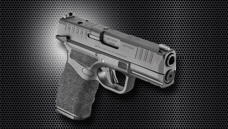 A black Springfield Armory Hellcat on a black honeycomb pattern background