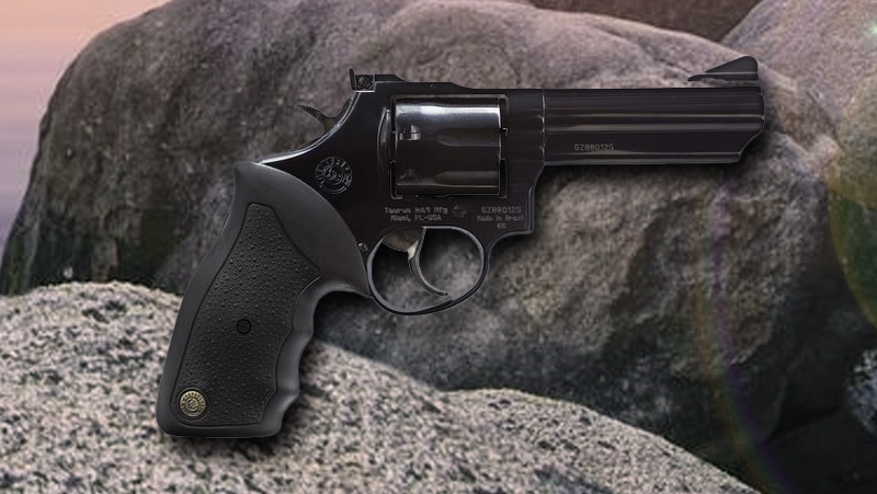 A black Taurus Model 66 placed before rocks