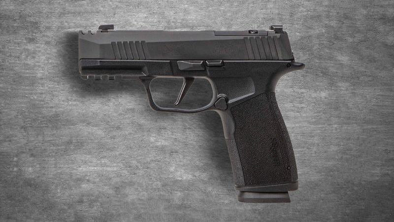 A black Sig Sauer P365 X-Macro rests on a smooth gray background, highlighting its sleek design